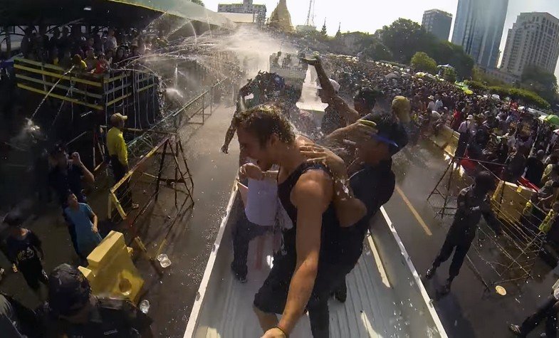 a male tourist is splashed water in Thingyan water festival