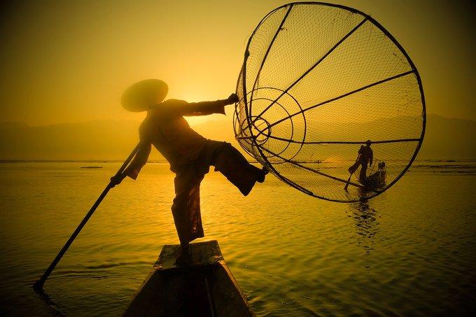 a fisherman holding fishnet by one leg