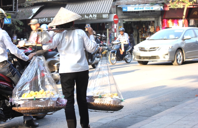 hawker carry the sticky rice cake on their shoulders and walking along the street