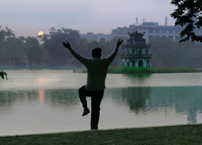 old woman practising Taichi near Hoan Kiem lake in the morning