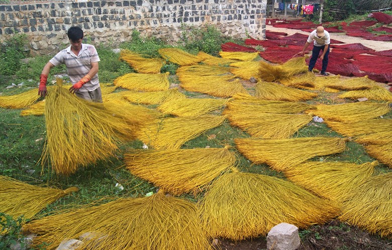 two men preparing straws to make sedge mats