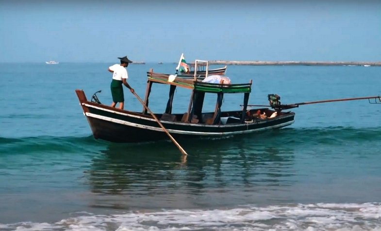 a fisherman is controlling his fishing boat near the coast of Ngapali