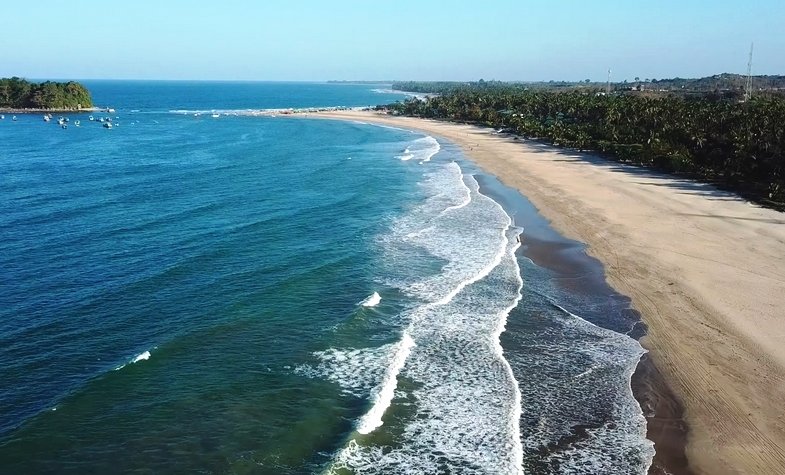 the waves gently embrace the shore of Ngwe Saung