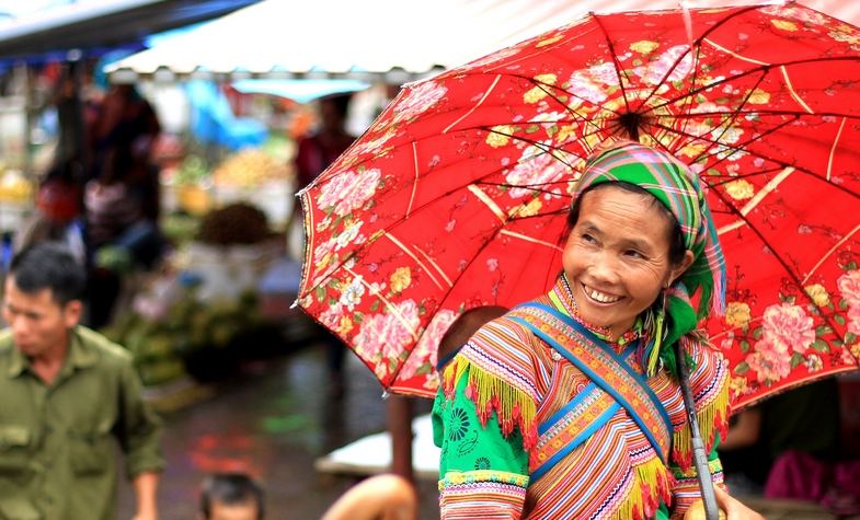 a smiling lady with red flower umbrella, going to Love market