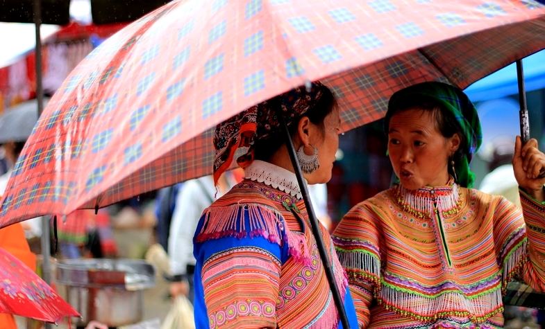two ladies greeting each other at the market