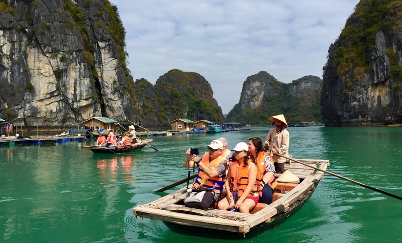 tourists recording the beautiful mountains on Ha Long Bay