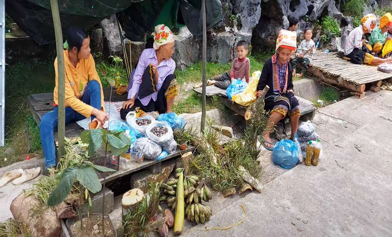 two old lady and their grandchilren beside their vegetable vendor at Mau Son hill market